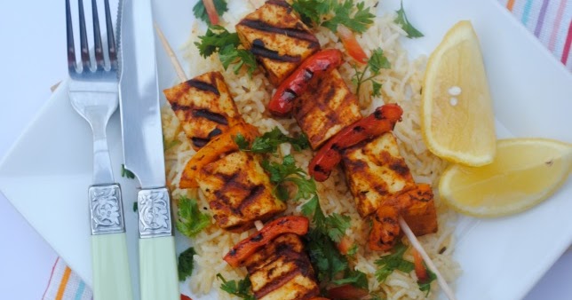 paneer tikka skewers on a plate with lemon slices