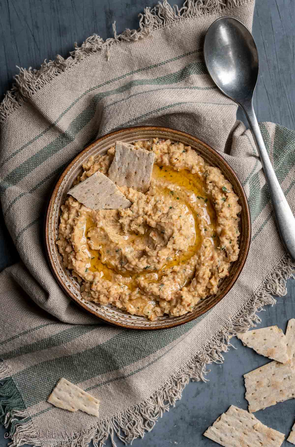 sriracha chickpea dip in a bowl with crackers