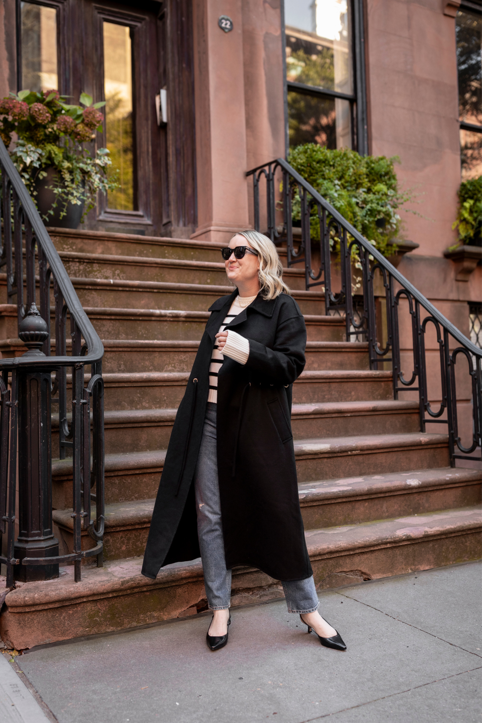  Wit Whimsy Blogger Meghan Donovan shares Winter Outfit Ideas - woman wearing a long coat, striped shirt, and denim pants
